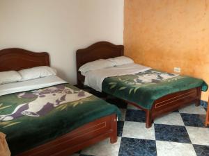 dwa łóżka siedzące obok siebie w pokoju w obiekcie Hotel SION w mieście Pitalito