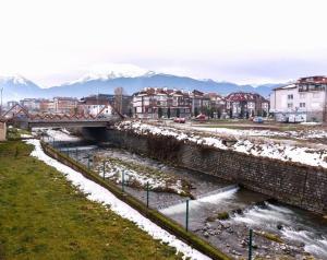 a bridge over a river in a city with snow at Bansko Ski & Relax Apartment in Bansko