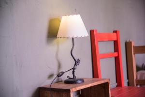 a lamp sitting on a table next to a red chair at Hostel La Humahuacasa in Humahuaca
