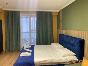 a bedroom with a large bed with towels on it at Brand new apartment near Gondola in Gudauri