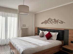 Postel nebo postele na pokoji v ubytování Hotel Rododendro Val di Fassa