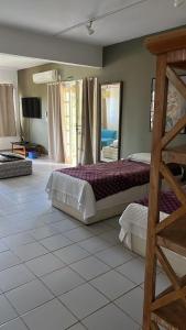 een slaapkamer met een stapelbed en een spiegel bij Pousada da Tina in Anchieta