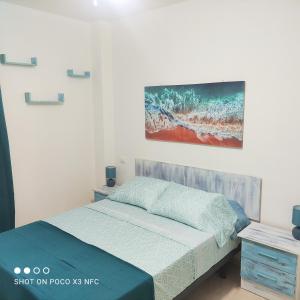 um quarto com uma cama e um quadro na parede em APARTAMENTO NAIR em Candelaria