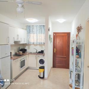 カンデラリアにあるAPARTAMENTO NAIRの白いキャビネットと茶色のドア付きのキッチン