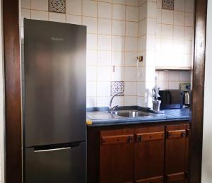 una cucina con frigorifero in acciaio inossidabile e lavandino di Apartamento playero Privado WiFi- MorroJable a Morro del Jable