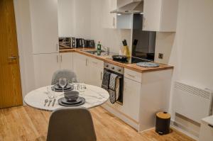 eine kleine Küche mit einem Tisch und Stühlen in der Unterkunft 1 bedroom Flat in Manchester in Manchester