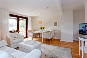 a living room with a white couch and a table at Lohmann's Ferienwohnung in Garstedt