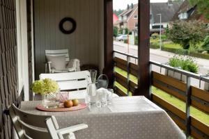 a table and chairs on a porch with a view of a street at Lohmann's Ferienwohnung in Garstedt