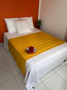 - un lit avec une couverture jaune et un bol rouge dans l'établissement Republique Lounge, à Fort-de-France