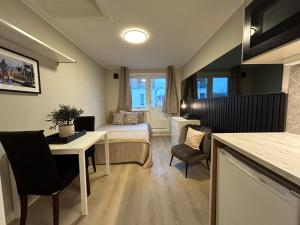 a small room with a bed and a table and chairs at Skippergata - Rooms in Kristiansand