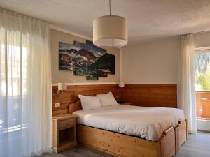 Postel nebo postele na pokoji v ubytování Hotel Rododendro Val di Fassa