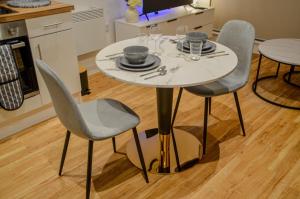 曼徹斯特的住宿－1 bedroom Flat in Manchester，一张带椅子和盘子的白色桌子和玻璃杯