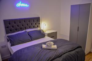 曼徹斯特的住宿－1 bedroom Flat in Manchester，卧室配有一张挂有墙上标志的床