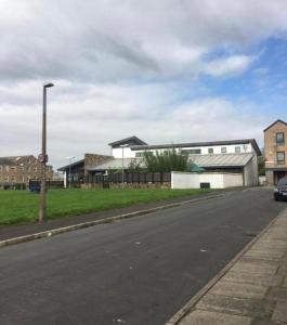 an empty street in front of a building at Luxury Travis House in Burnley