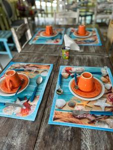 una mesa de madera con platos de comida y tazas. en Pousada da Tina, en Anchieta