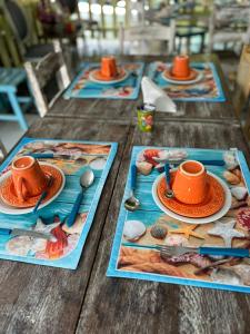 a wooden table with plates of food and cups on them at Pousada da Tina in Anchieta