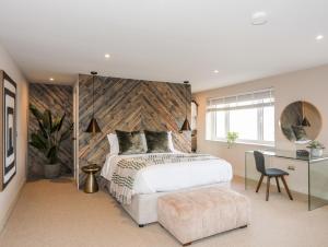 a bedroom with a large white bed and a desk at The Hayloft in Amlwch
