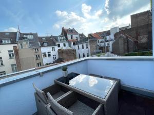 een balkon met een tafel en stoelen op een dak bij Friesenwall Apartments in Keulen