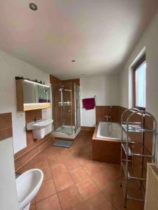 La salle de bains est pourvue de 2 lavabos, d'une baignoire et d'une douche. dans l'établissement Friesenwall Apartments, à Cologne
