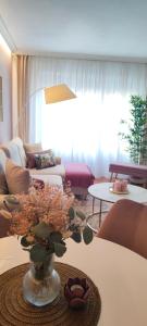 una sala de estar con un jarrón con flores sobre una mesa en Fruela Centro- Parking gratuito, en Oviedo