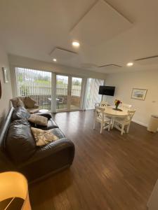 a living room with a leather couch and a table at Park Avenue Apartment in Newcastle