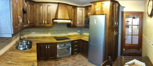 uma cozinha com armários de madeira e um frigorífico azul em CASA LAURA em Iznájar