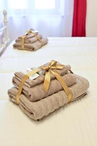 two beds with towels and a bow on them at La Casa nel Vicolo in Colle di Val d'Elsa