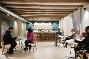 a group of people sitting at tables in a restaurant at Hostal Porxos Garden in Barcelona