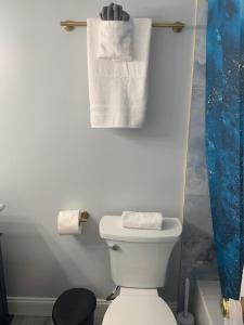 哈兰代尔海滩Walk to the beach, Studio, with Pool and FREE Parking的浴室配有卫生间和墙上的毛巾。