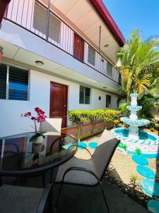 eine Terrasse mit einem Glastisch, Stühlen und einem Brunnen in der Unterkunft Hostal Clary in León