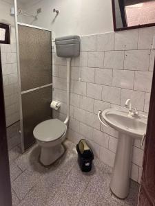 a bathroom with a toilet and a sink at Pousada Felicitá in Imbé