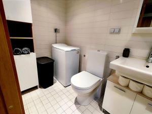 uma casa de banho branca com um WC e um lavatório em Enjoy luxury and convenience @best area of Tallinn em Talin