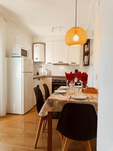 Il comprend une cuisine équipée d'une table avec des chaises et d'un réfrigérateur blanc. dans l'établissement Coqueto apto en centro histórico, à Marbella