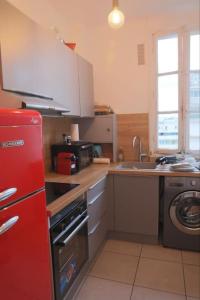 a kitchen with a red refrigerator and a sink at Profitez du calme de Courbevoie La Défense in Courbevoie