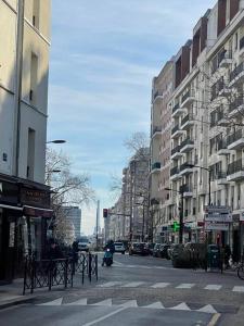 a city street with buildings and a person on a motorcycle at Profitez du calme de Courbevoie La Défense in Courbevoie