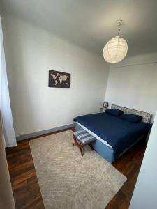 a bedroom with a blue bed and a rug at Profitez du calme de Courbevoie La Défense in Courbevoie