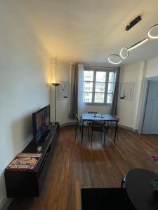 a living room with a couch and a dining room table at Profitez du calme de Courbevoie La Défense in Courbevoie