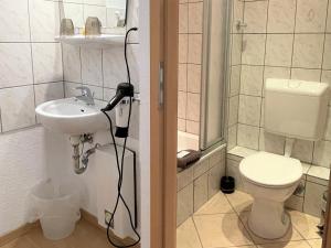 ein Bad mit einer Dusche, einem Waschbecken und einem WC in der Unterkunft Hotel Antoni in Bochum