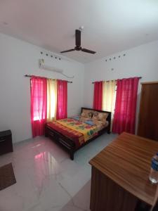 New PALM BAY RESIDENCY في فاركَالا: غرفة نوم بسرير وستائر حمراء