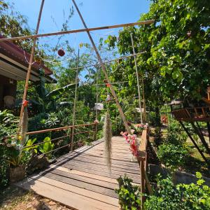 een houten loopbrug in een tuin met planten bij Easy Life Country House in Koh Lanta