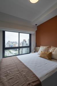 a bedroom with a large bed with a large window at Studio Alto Padrão Brooklin in Sao Paulo