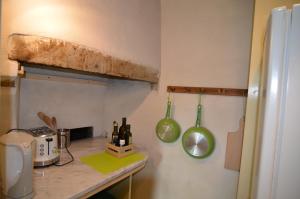 a kitchen with a counter with two green cooking utensils at Country House Il Covo della Civetta in Barberino di Val dʼElsa