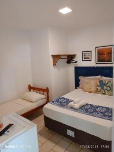 sypialnia z 2 łóżkami i stołem w obiekcie Pousada Anturio w mieście Barra Velha