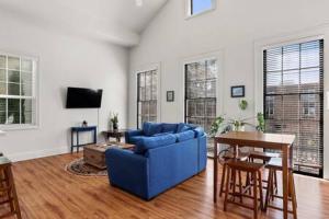 sala de estar con sofá azul y mesa en Timeless Elegance Historic NOLA Haven 2BD en Nueva Orleans