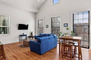 ein Wohnzimmer mit einem blauen Sofa und einem Tisch in der Unterkunft Timeless Elegance Historic NOLA Haven 2BD in New Orleans