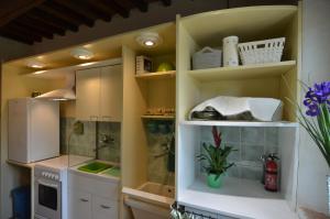 a kitchen with white cabinets and a white refrigerator at Country House Il Covo della Civetta in Barberino di Val dʼElsa