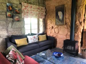 a living room with a couch and a stove at Franshoek Farm in Ficksburg