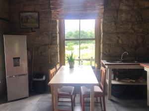 a kitchen with a table and a refrigerator and a window at Franshoek Farm in Ficksburg