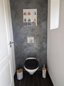 La salle de bains est pourvue de toilettes et d'un couvercle noir. dans l'établissement Maison cosy - 10min Nantes, gare et aéroport, à Rezé