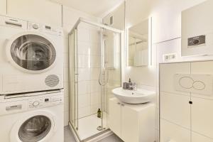 a white bathroom with a washing machine and a sink at Olivia -Einzigartiges Wohnerlebnis in Kaiserslauterns Herz in Kaiserslautern +10 photos
